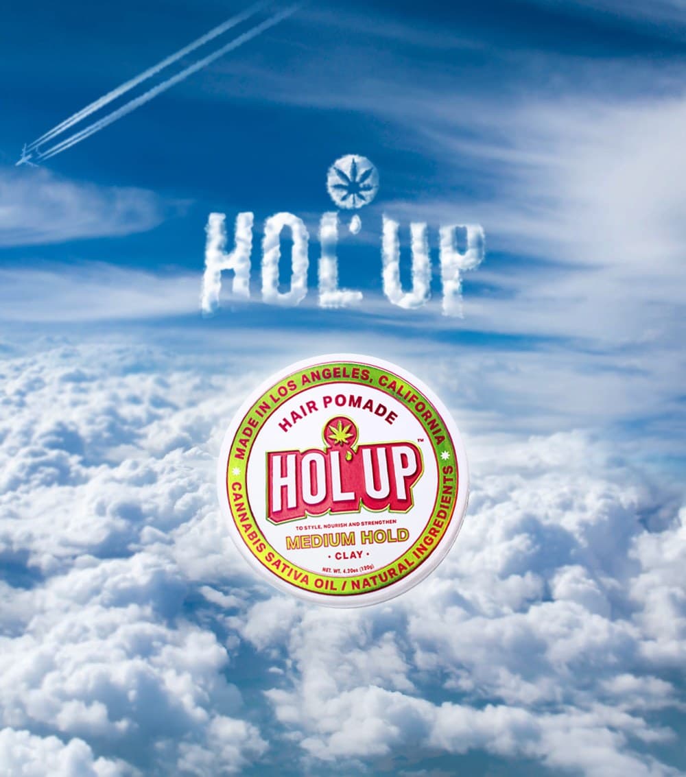 HOL'UP brand campaign — pomade tin floating above clouds with skywriting logo