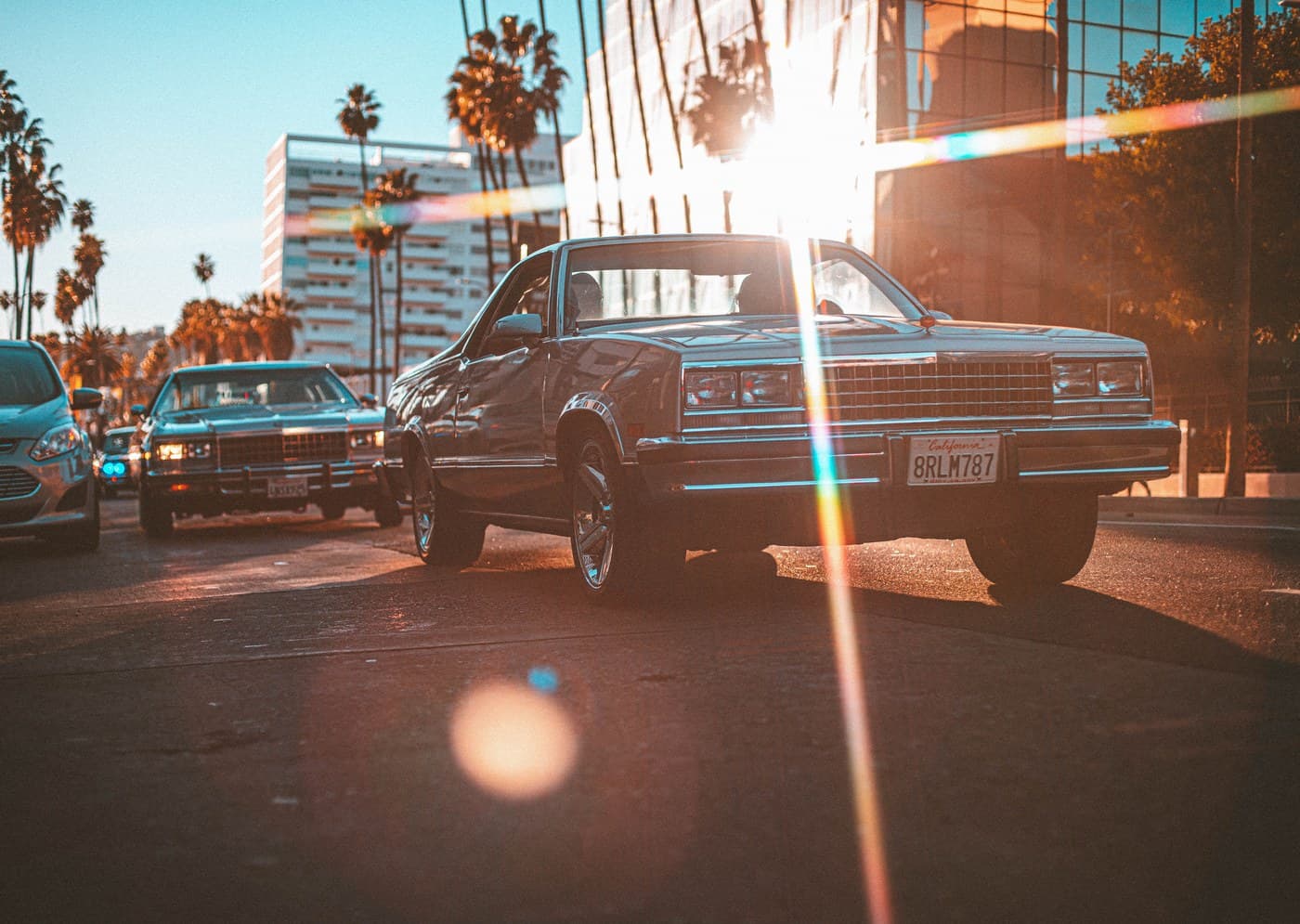 Lowrider Cadillac at Los Angeles golden hour with rainbow lens flare
