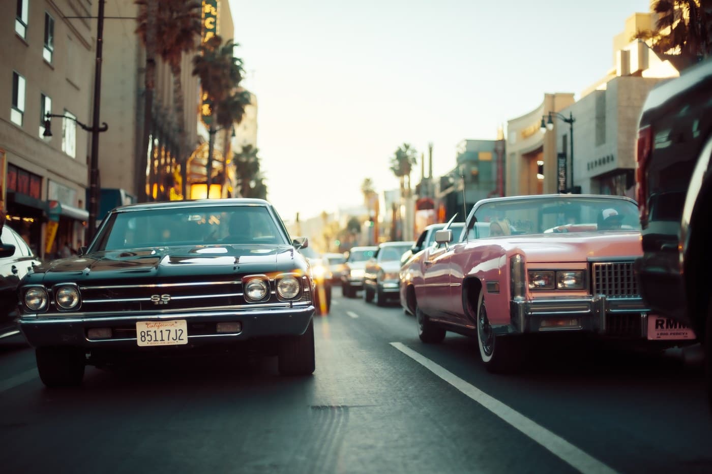 Chevy SS 396 and pink Cadillac on Hollywood Boulevard at golden hour