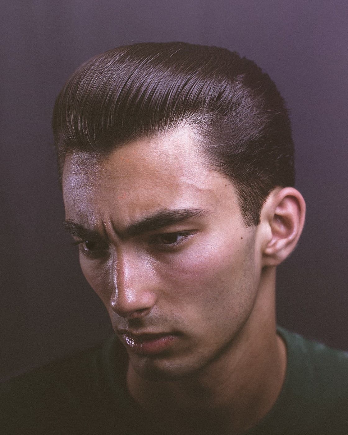 Classic slicked-back pompadour portrait on moody purple studio background