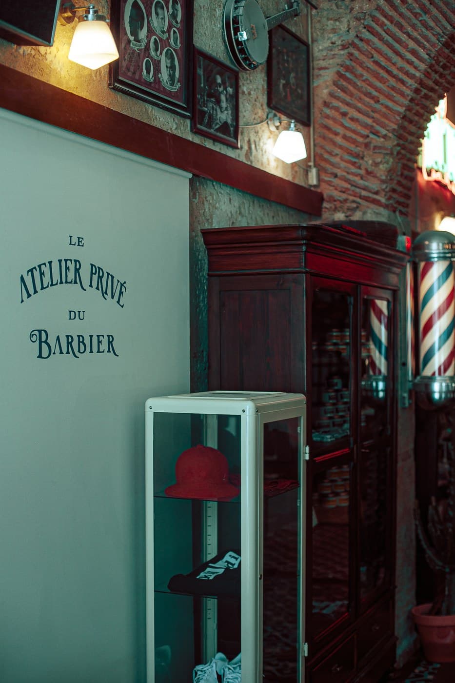 Le Atelier Privé du Barbier — branded interior with display case and barber pole
