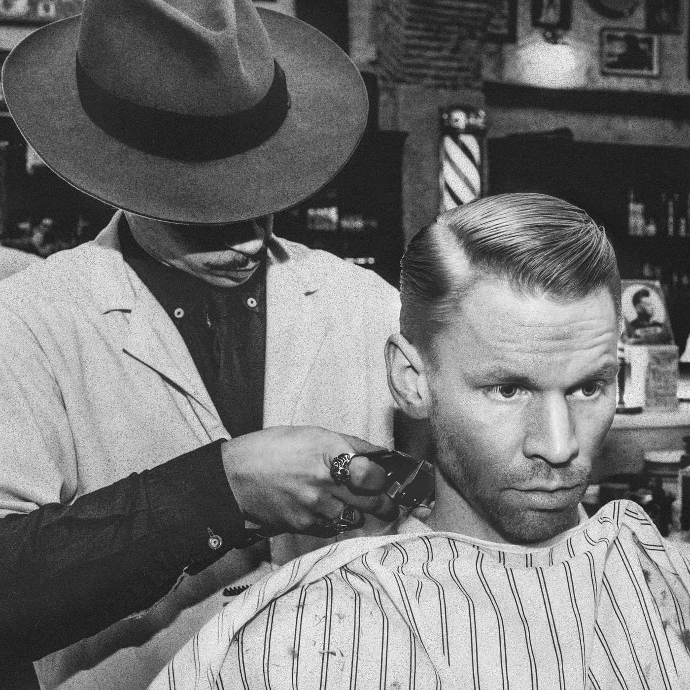 Black and white square — barber with wide-brim hat cuts a classic pompadour client
