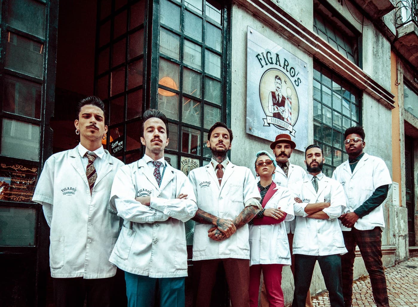 Figaro's Barbershop team outside the shop facade under the branded sign
